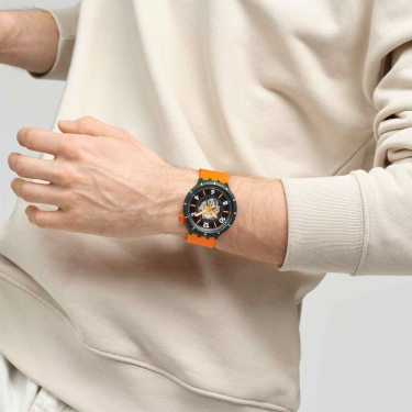 Swatch FALL-IAGE : grande montre, cadran laqué noir et argenté, boîtier BIOCERAMIC vert mat, et bracelet orange mat.